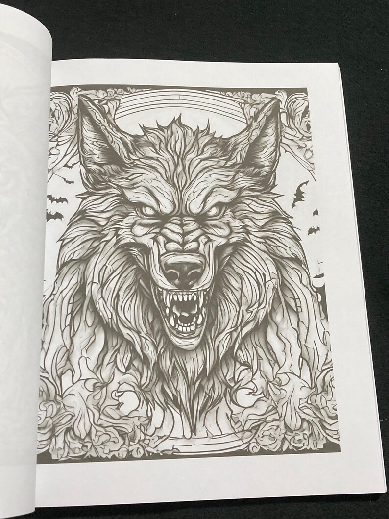K&ouml;nnte beinhalten: Detaillierte Schwarz-Wei&szlig;-Illustration eines knurrenden Wolfsgesichts mit scharfen Z&auml;hnen und intensiven Augen. Das Kunstwerk ist Teil eines Malbuchs mit komplizierten Mustern und dekorativen Elementen, einschlie&szlig;lich Flederm&auml;usen.