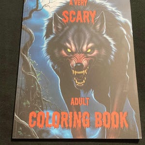 K&ouml;nnte beinhalten: Ein sehr gruseliges Malbuch f&uuml;r Erwachsene. Das Cover zeigt einen knurrenden Wolf mit leuchtend gelben Augen und scharfen Z&auml;hnen. Der Titel ist in roter, stilisierter Schrift auf einem dunklen, bedrohlichen Hintergrund.