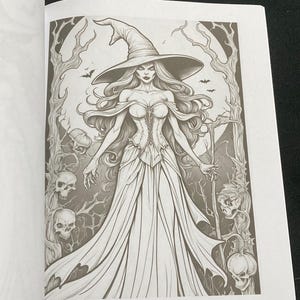 K&ouml;nnte beinhalten: Graustufen-Illustration einer Hexe mit langem Haar, die einen spitzen Hut und ein langes Kleid tr&auml;gt. Die Hexe ist von Totenk&ouml;pfen, Flederm&auml;usen und knorrigen B&auml;umen umgeben, was ein gruseliges, gotisches Thema erzeugt.