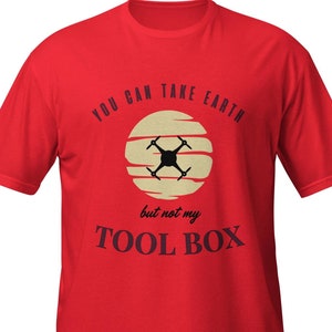 Könnte beinhalten: Rotes T-Shirt mit einem Drohnen-Motiv in einem Sonnen-Design. Der Text "YOU CAN TAKE EARTH but not my TOOL BOX" ist in Dunkelblau gehalten. Das T-Shirt hat einen Rundhalsausschnitt.