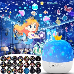 May include: A white and blue night light projector with a yellow crown on top. The projector displays a blue starry sky with jellyfish, fish, and a mermaid. Includes interchangeable discs with various themes.