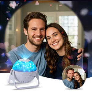 May include: A white star projector with a blue light and a clear plastic dome. The projector is on a white surface and is surrounded by hearts.