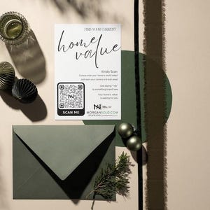 May include: A still life composition includes a white card with the text "home value" and a QR code, a green envelope, and decorative baubles. The card reads "Find Your Current Home Value" and includes the website morgansold.com.