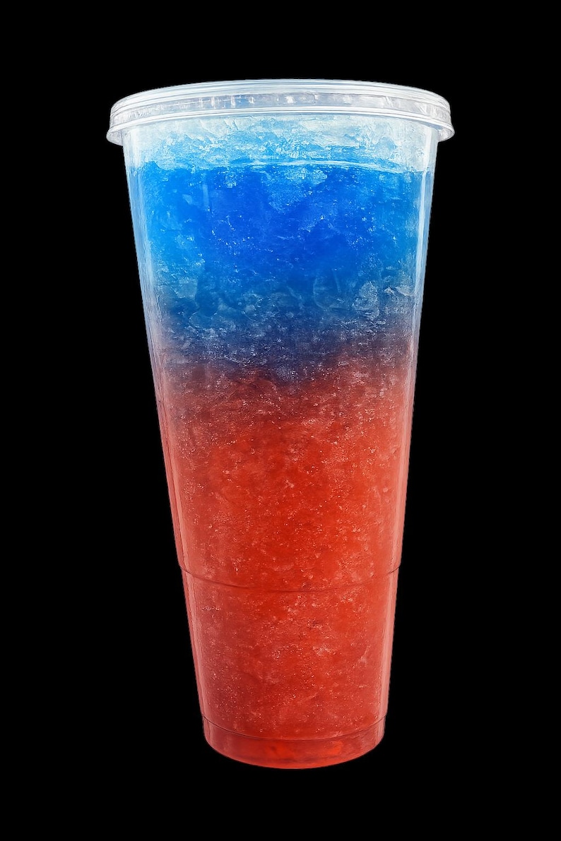 May include: A clear plastic disposable cup filled with a layered frozen slushy beverage. The drink features a distinct horizontal color gradient, transitioning from a vibrant blue at the top to a bright red at the bottom, with crushed ice texture.