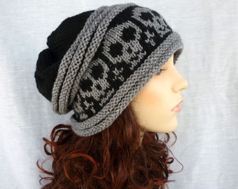 May include: A black and gray knit beanie with a skull pattern. The beanie is folded down and has a slouchy fit.