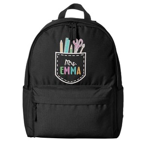 May include: Black backpack with a front pocket featuring school supplies and the text "Mrs. Emma" in colorful letters. The pocket design includes pencils, a ruler, and scissors. The backpack has a top handle and a zippered main compartment.