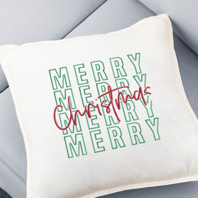 May include: A square, off-white decorative pillow with the words "MERRY" stacked vertically in green block letters. The word "Christmas" is written in red cursive script across the center of the pillow, creating a festive holiday design.