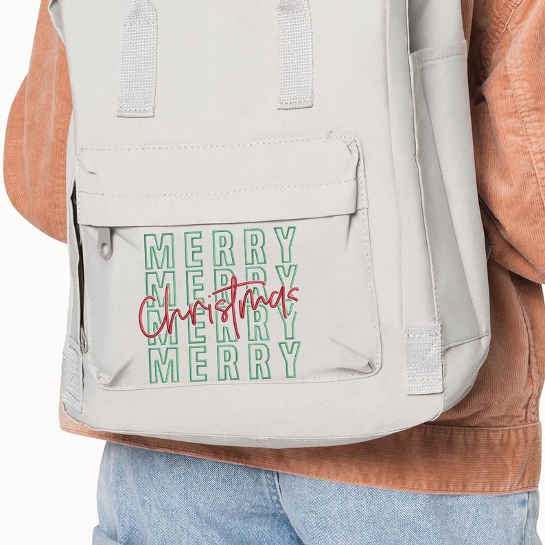 May include: A light gray backpack with a front pocket. The words "MERRY CHRISTMAS" are printed on the front in green and red. The backpack has a top handle and adjustable straps.
