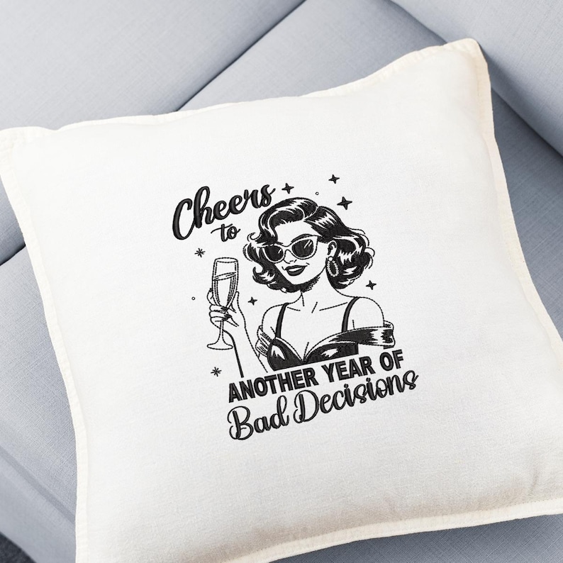 May include: Off-white square throw pillow with a black and white graphic of a woman in sunglasses holding a champagne glass. Text reads "Cheers to Another Year of Bad Decisions."