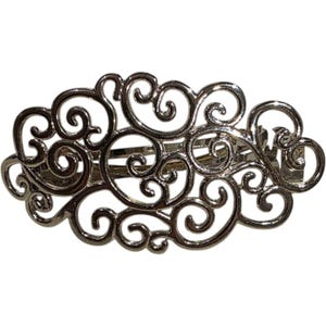 Könnte beinhalten: Haarspange aus silberfarbenem Metall mit einem durchbrochenen Design aus wirbelnden, scrollartigen Mustern. Die Spange hat eine rechteckige Form und einen Verschluss auf der Rückseite. Ein dekoratives Haaraccessoire.
