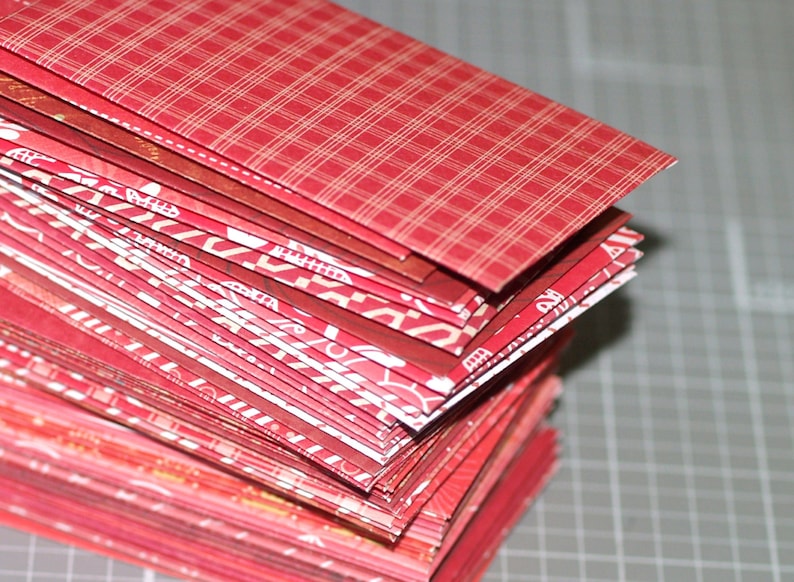 Peut inclure: Une pile d'enveloppes &agrave; motifs rouges et blancs. L'enveloppe du dessus a un motif &agrave; carreaux rouges et blancs.