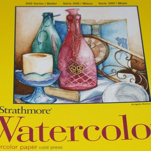 May include: A watercolour painting of a still life featuring a candle, a glass bottle, a clock, and a book. The painting is on a yellow background with the text "Strathmore Watercolor" and "Watercolor paper cold press" printed below the image. The artist's name, "Bridgette Blanton", is printed in the bottom right corner.