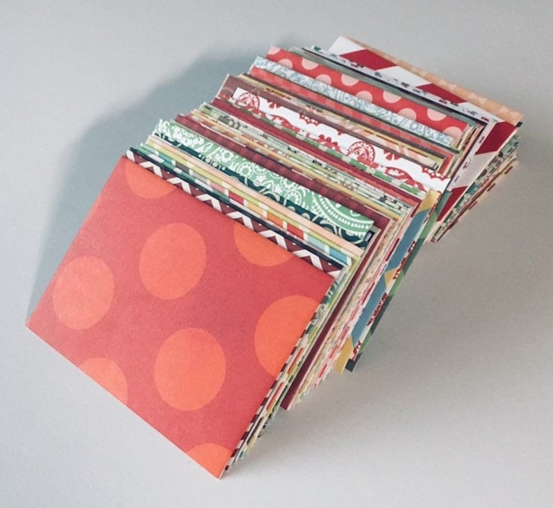 Peut inclure: Une pile d'enveloppes en papier &agrave; motifs color&eacute;s, avec une enveloppe rouge &agrave; pois blancs sur le dessus.