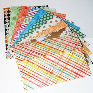May include: A stack of colorful patterned paper envelopes, with a plaid envelope on top.