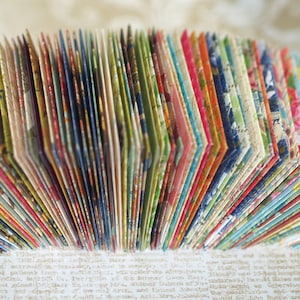 May include: A close-up of a stack of colorful patterned paper cards. The cards are arranged in a fan shape, revealing the intricate designs on each card.