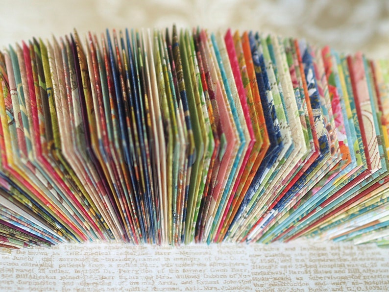 May include: A close-up of a stack of colorful patterned paper cards. The cards are arranged in a fan shape, revealing the intricate designs on each card.