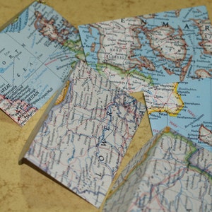 May include: Four vintage maps of different regions of the world. The maps are printed on paper and have a worn, aged look. The maps are all in different colors and have different levels of detail. The maps are all in good condition and would be a great addition to any collection.