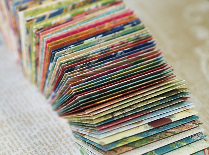 May include: A stack of colorful patterned paper envelopes, folded and fanned out, revealing a variety of designs and textures.