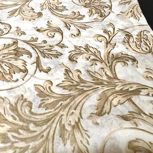 May include: A white background with a brown and gold damask pattern. The pattern features intricate swirls and leaves.
