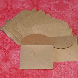 May include: A stack of brown paper envelopes with rounded corners. The envelopes are arranged in a fan shape and are ready to be used for sending letters or small gifts.
