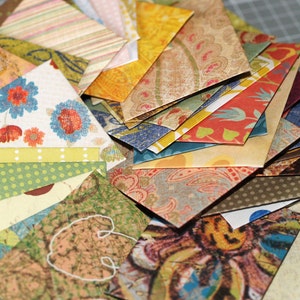 May include: A stack of colorful patterned paper envelopes, some with floral designs, others with geometric patterns, and some with paisley designs.