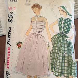 Puede incluir: Un patrón de costura vintage Simplicity para un vestido, talla 16, pecho 86 cm. El patrón está impreso en papel blanco con un vestido de cuadros verdes y blancos a la derecha y un vestido rosa a la izquierda. El patrón se titula "Simplicity Printed Pattern 25c".