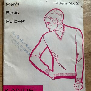 May include: A vintage knitting pattern for a basic pullover sweater. The pattern is printed on a white paper with pink text and illustrations. The pattern number is 2 and the price is $1.25. The text reads "Men's Basic Pullover" and "Kandel Knits Patterns from a Professional Knitting Mill."