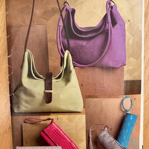 May include: Vogue accessories pattern featuring various bag designs. The image showcases a purple shoulder bag, a light green handbag, and several small clutch bags in pink, gray, and blue. The pattern includes the text "V0683 PATTERN/PATRON ONE SIZE UNE SEULE TAILLE".