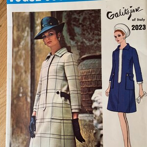 May include: A vintage Vogue Couturier Design pattern featuring a checkered dress and a blue dress with a white collar. The pattern is from Galitzine of Italy and is dated 2023.