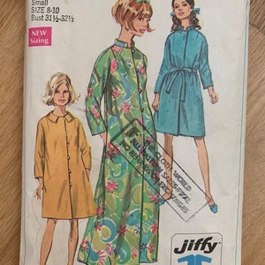 May include: Simplicity sewing pattern number 7958 for a dress. The pattern is for sizes 8-10 and has a bust measurement of 31 1/2 to 32 1/2 inches. The pattern includes three different dress styles, one with a floral print, one in a solid blue color, and one in a solid yellow color. The pattern is labeled "easy cut - easy sew" and includes two main pattern pieces. The pattern is 65 cents and 75 cents in Canada.