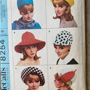 May include: A vintage sewing pattern for six different hat styles. The pattern is for sizes small and large. The pattern is printed on a white background with a blue border. The pattern includes a blue, red, yellow, black and white polka dot, black and white checkered, and red and white hat.