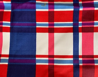May include: Red, white, blue, and purple plaid fabric with a woven texture.