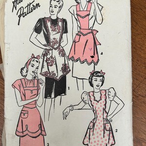 May include: Vintage sewing pattern featuring illustrations of aprons. The pattern includes various apron designs, including a floral apron, a polka-dot apron, and aprons with pocket details. The text "Advance Pattern" is visible at the top.