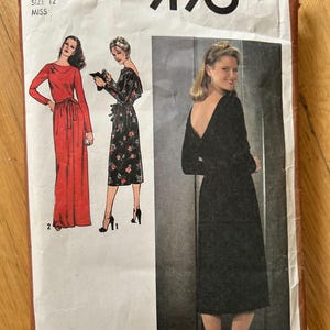 Puede incluir: Patrón de costura Simplicity número 9190 para un vestido. El patrón es para la talla 12 miss. El patrón muestra tres estilos de vestidos diferentes, uno rojo, uno negro y uno de estampado floral.