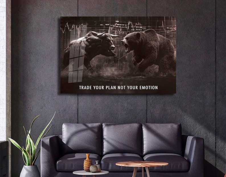 May include: A sepia-toned wall art print depicting a bull and a bear, representing the stock market. The print includes the text "TRADE YOUR PLAN NOT YOUR EMOTION" in white. The artwork is displayed above a black leather sofa.