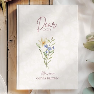 Puede incluir: Un libro de tapa dura con una cubierta de color crema que presenta un sutil patrón floral. El texto dice Dear GOD, letters from OLIVIA BROWN. Una ilustración central en acuarela muestra un pequeño ramo de flores silvestres amarillas y azules.