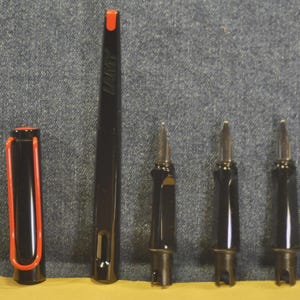 K&ouml;nnte beinhalten: Schwarzer F&uuml;llfederhalter mit roten Akzenten, einschlie&szlig;lich Kappe und Clip. Der Stiftk&ouml;rper ist schwarz und der Clip rot. Das Bild zeigt auch die Federn des Stifts und andere Komponenten.