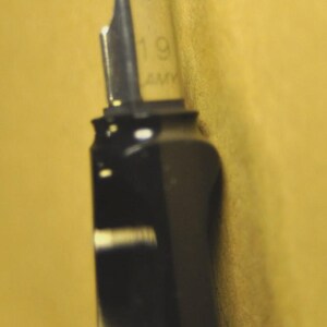 K&ouml;nnte beinhalten: Nahaufnahme eines schwarzen F&uuml;llfederhalters mit silberner Feder. Auf der Feder sind die Zahl "19" und die Buchstaben "AM" eingraviert. Der Stift befindet sich vor einem gelben Hintergrund.