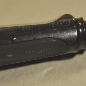 K&ouml;nnte beinhalten: Ein F&uuml;llfederhalter mit einem silberfarbenen Schaft und einem transparenten, dunkelgrauen Griffst&uuml;ck. Die Metallfeder ist mit dem Text LAMY und EF graviert. Der F&uuml;ller verf&uuml;gt &uuml;ber einen schwarzen Verbindungsring zwischen Schaft und Griffst&uuml;ck.