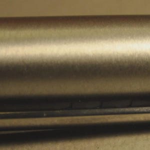 May include: Close-up of a silver-colored pen with a clip. The pen's body has a brushed metal finish. The clip is rectangular with the brand name "LAMY" engraved on it.