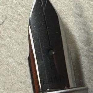 Może przedstawiać: Zbliżenie srebrnej stal&oacute;wki pi&oacute;ra wiecznego. Stal&oacute;wka jest czarna z cienką końc&oacute;wką i widoczną nazwą marki "LAMY". Pi&oacute;ro ma metaliczny srebrny korpus.