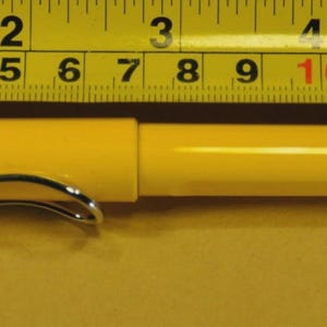 Puede incluir: Un bol&iacute;grafo amarillo con un clip plateado, de aproximadamente 14 cm de largo, est&aacute; colocado junto a una cinta m&eacute;trica amarilla y negra. El bol&iacute;grafo es cil&iacute;ndrico con una tapa. La cinta m&eacute;trica muestra medidas en pies y pulgadas.