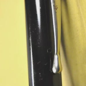 Puede incluir: Un capuch&oacute;n de pluma estilogr&aacute;fica negro con un clip de metal plateado pulido fijado en la parte superior. El capuch&oacute;n tiene un acabado liso y brillante con dos finas l&iacute;neas horizontales grabadas que rodean la secci&oacute;n inferior cerca de la base.