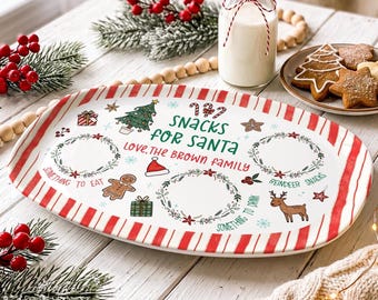May include: An oval white ceramic serving platter with red striped edges, featuring the text "SNACKS FOR SANTA" and "LOVE, THE BROWN FAMILY," decorated with illustrations of a Christmas tree, reindeer, gingerbread man, and wreaths.