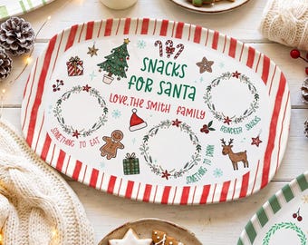 May include: An oval ceramic serving platter with a red and white striped border. The center features the text "Snacks for Santa" and "Love, The Smith Family," surrounded by illustrations of a Christmas tree, gingerbread man, reindeer, and wreaths.