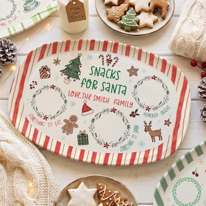 Könnte beinhalten: Eine ovale Servierplatte aus Keramik mit einem rot-weiß gestreiften Rand. In der Mitte befindet sich der Text "SNACKS FOR SANTA" und "LOVE, THE SMITH FAMILY", umgeben von Illustrationen eines Weihnachtsbaums, Rentiers, Lebkuchenmanns und Kränzen.