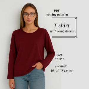 Peut inclure: Un t-shirt bordeaux à manches longues. Le t-shirt est de couleur unie avec un col rond. L'image comprend également le texte "PDF sewing pattern", "T-shirt with long sleeves", "SIZE XS-3XL" et "Format: A0/A4/US Letter".