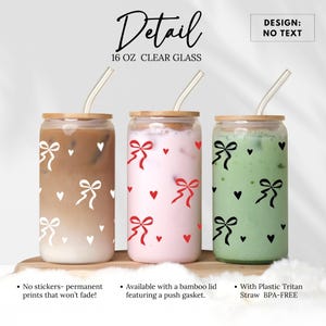 May include: Three 16 ounce clear glass tumblers with bamboo lids and reusable straws. The tumblers have a white, red, and black pattern of bows and hearts.  DESIGN: NO TEXT