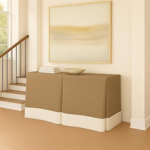 May include: A two-section, tan-colored cabinet with a white base, topped with a stack of books and a light-colored bowl. A framed abstract painting hangs above the cabinet. The scene is set in a well-lit hallway with a staircase.