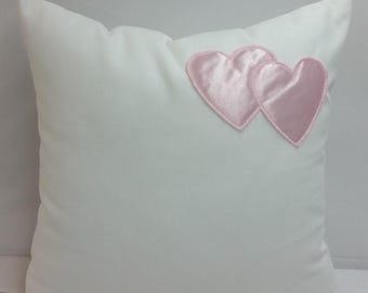White cotton throw pillow with appliqued pink hearts, nursery, girls room, kids play room, children